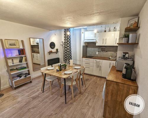 une cuisine avec une table et des chaises dans une pièce dans l'établissement Douceur Nîmoise en centre ville - RDC et extérieur, à Nîmes