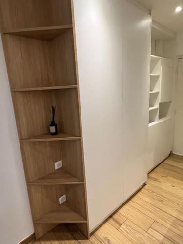 Cette chambre dispose d'un placard avec des étagères en bois. dans l'établissement Appartement dans résidence avec piscine, à Villeneuve-Loubet