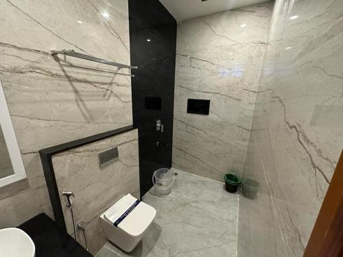 a bathroom with a white toilet and a shower at 100 Oaks Estate in Yercaud