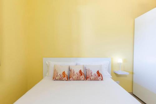 a bedroom with a white bed with two pillows at Incantevole Vista Mare, 450mt Spiaggia Kal'e Moru in Geremèas