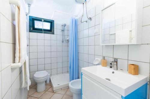 a white bathroom with a toilet and a sink at Incantevole Vista Mare, 450mt Spiaggia Kal'e Moru in Geremèas