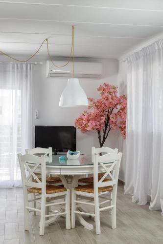 a white dining room with a table and chairs at Villino Blu by the sea in Gouves
