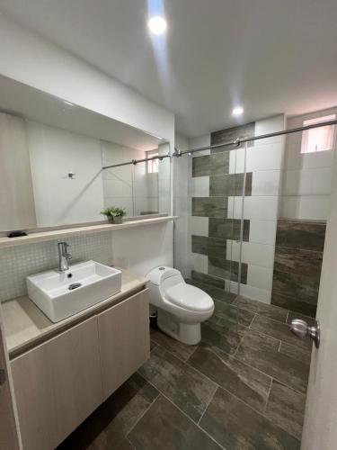 a bathroom with a toilet and a sink and mirror at Apartamento espectacular 3-4 habitaciones sabaneta in Sabaneta