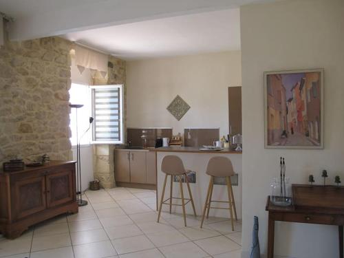- une cuisine avec 2 chaises et un comptoir dans une pièce dans l'établissement Appartement Nimes avec terrasse ouverte, à Nîmes
