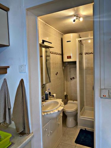 une salle de bain avec un lavabo, des toilettes et une douche dans l'établissement écho des vagues , vue mer, à Langrune-sur-Mer