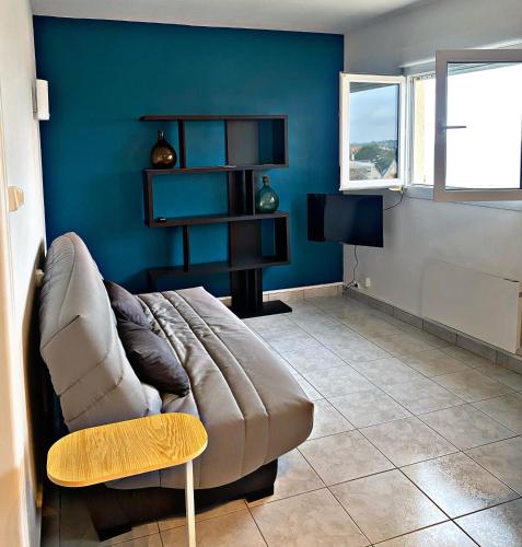 un salon avec un canapé et un bureau dans l'établissement écho des vagues , vue mer, à Langrune-sur-Mer