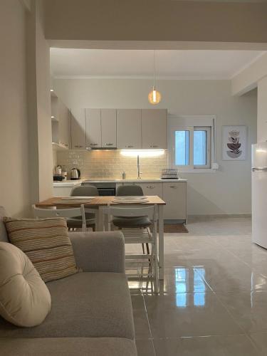 a kitchen and living room with a couch and a table at Kamena Elegance in Kamena Vourla