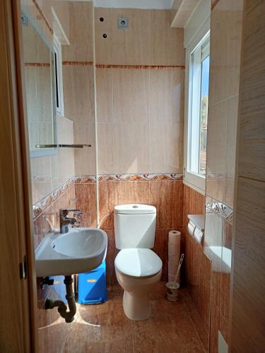 a bathroom with a toilet and a sink and a window at Hospedaje casaAlfredo in Algeciras