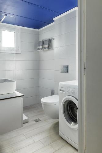 a bathroom with a toilet and a washing machine at Villino Blu by the sea in Gouves