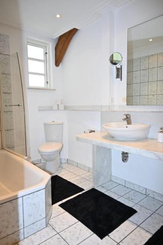 a bathroom with a sink and a tub and a toilet at Gemütliches Fachwerkhaus in Werne an der Lippe