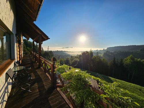 a balcony of a house with a view of the mountains at Chata w Bieszczadzie apartamenty i domki z basenem Bieszczady in Polańczyk