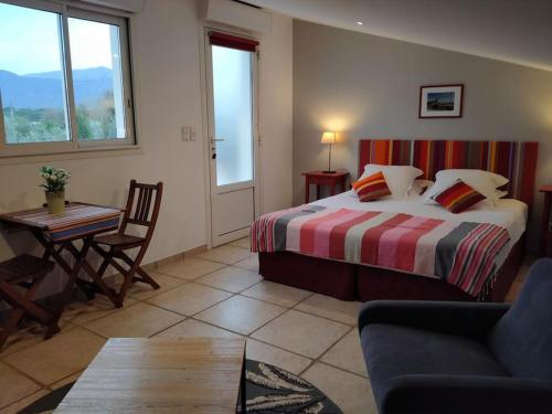une chambre avec un lit, une table et une chaise dans l'établissement Mas Picton Maison 4 chambres dans Mas piscine proche mer, à Argelès-sur-Mer