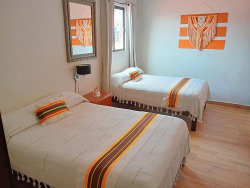 a room with two beds and a mirror at Grann Posada Xilitla in Xilitla