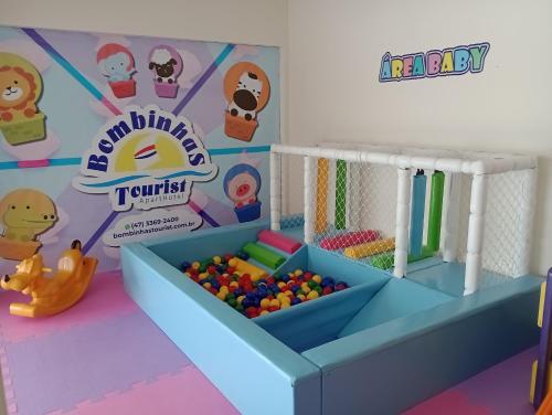 a toy room with a crib and balls at Bombinhas Tourist Apart in Bombinhas