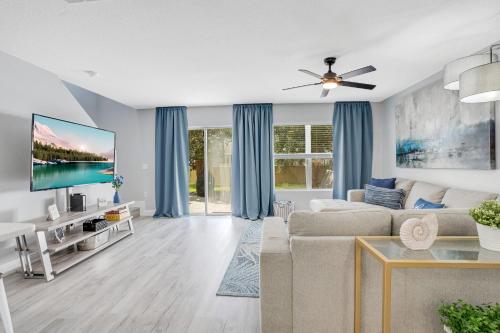 a living room with a couch and a flat screen tv at Stylish Villa Near Disney & Universal in Kissimmee