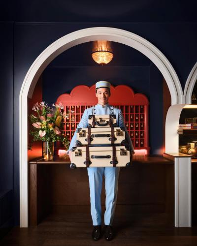 a man is holding a suitcase in a kitchen at The Georgian Hotel in Los Angeles
