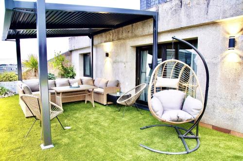 a patio with a swing and chairs on the grass at Lucus Skyline & Terrace by Lugo Collection in Lugo