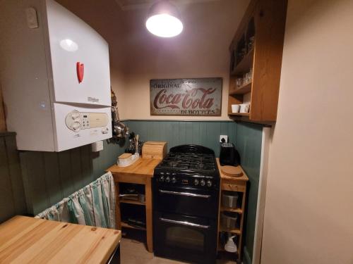 una pequeña cocina con fogones negros en Nelson's View, en Ryde