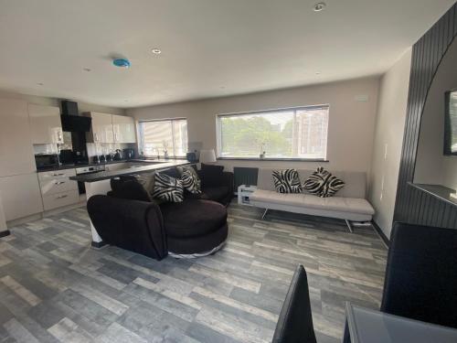 a living room with two couches and a kitchen at Rivendell spacious two bedroom 1st floor flat in Kent