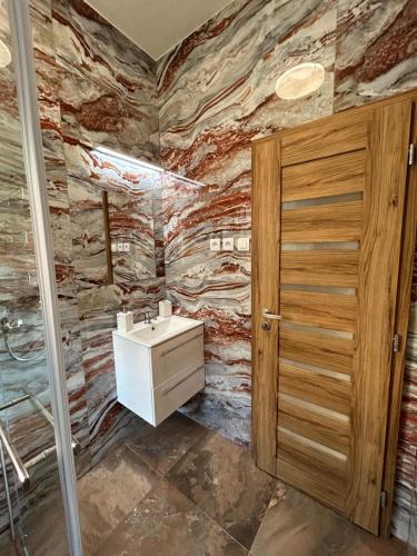 a bathroom with a stone wall with a sink at Penzión Stratenka in Stratená
