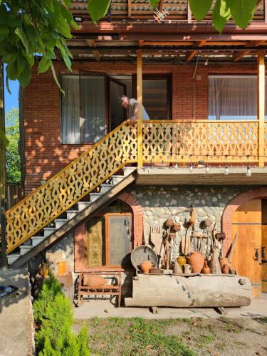 a person standing on the stairs of a house at Lomtadze Family Wine Hotel in Ambrolauri