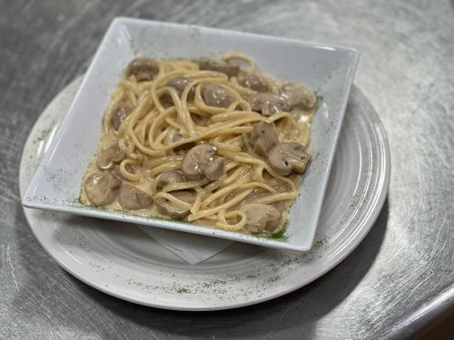 a bowl of noodles and mushrooms on a plate at LA CASONA DE PALMIRA in Caín
