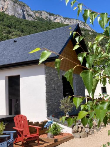 a house with a red chair in front of it at Le chalet Paula in Agos-Vidalos