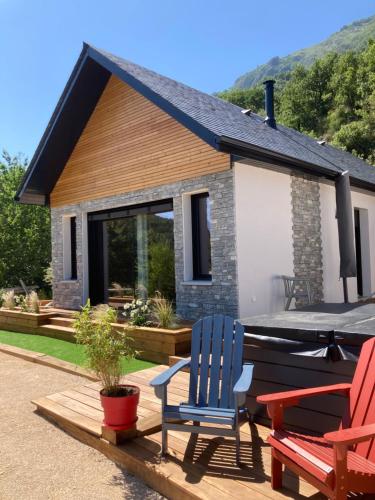 two chairs sitting on a deck in front of a house at Le chalet Paula in Agos-Vidalos