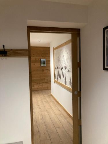 a hallway with a wooden door and a painting on the wall at Le chalet Paula in Agos-Vidalos