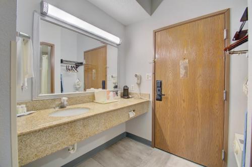 a bathroom with a sink and a large mirror at Quality Inn & Suites CVG Airport in Erlanger