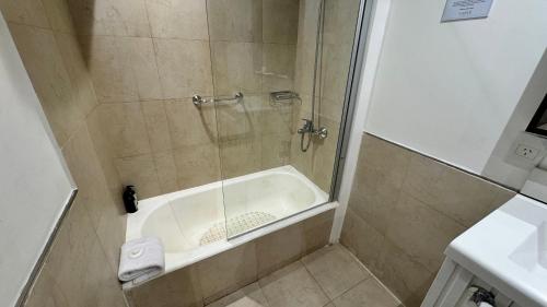 a bathroom with a shower with a bath tub at Gardi Hotel & Suites in Buenos Aires