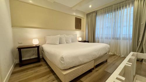 a bedroom with a large white bed and a window at Gardi Hotel & Suites in Buenos Aires