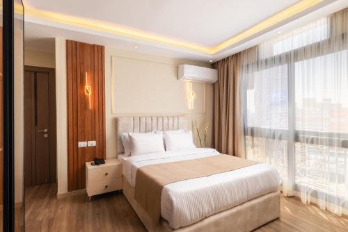 a bedroom with a large bed and a large window at Museum And Nile View Hotel in Cairo