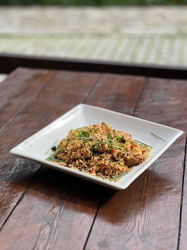 a white plate of food on a wooden table at LA CASONA DE PALMIRA in Caín