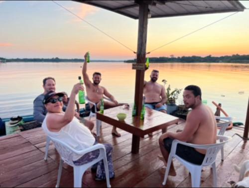a group of men sitting around a table drinking beer at Amazônia LODGE Exxperience in Manaus