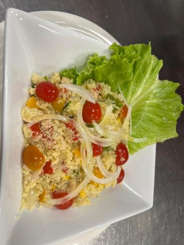 a white plate of food with lettuce and tomatoes at LA CASONA DE PALMIRA in Caín