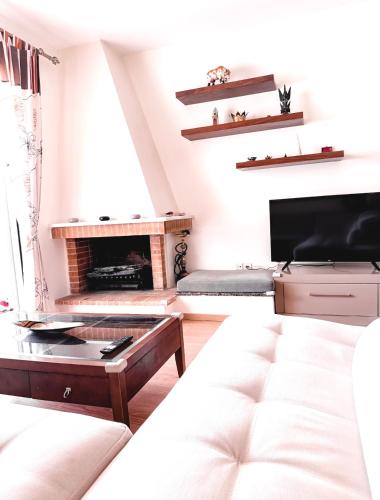 a living room with a couch and a fireplace at Aegean Pearl in Porto Rafti