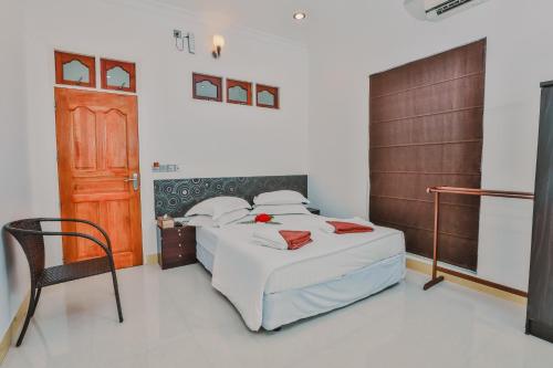a bedroom with a bed and a wooden door at Karanka Villa @ Mahibadhoo in Mahibadhoo