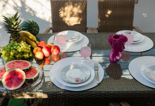 a table with plates of food and fruit on it at Villino Blu by the sea in Gouves