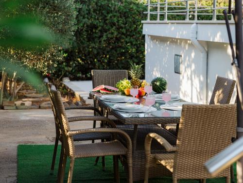 an outdoor table with chairs and a table with food on it at Villino Blu by the sea in Gouves
