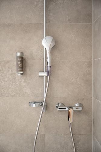 a shower with a shower head in a bathroom at Ruhpoldinger Hof - Hotel & Wellness in Ruhpolding