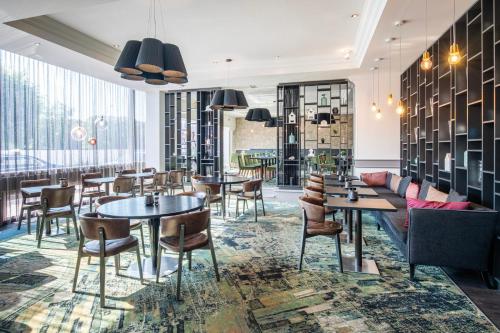 a restaurant with tables and chairs and a couch at Crowne Plaza Antwerpen by IHG in Antwerp
