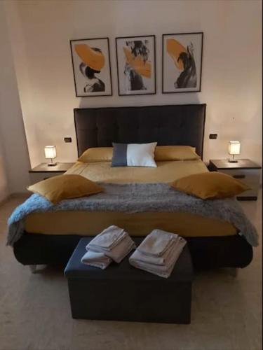 a bedroom with a large bed with three pictures on the wall at Appartamento DAF House in Roccasecca