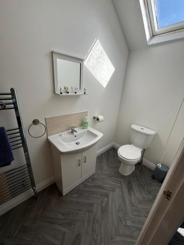 a bathroom with a toilet and a sink at White Swan Cottage in Hunmanby