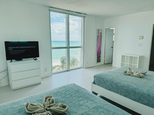 Un dormitorio con dos camas y un televisor de pantalla plana. en The Tides Condo on Hollywood, en Hollywood