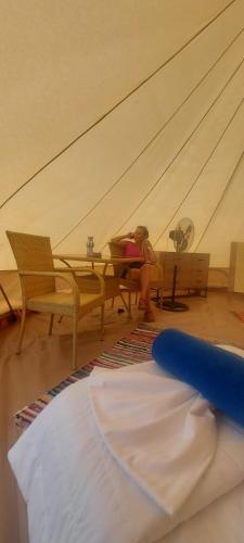 a woman sitting at a table in a room at Ioannina Camping- Glamping in Neo Mpizani