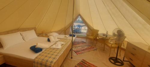 a bedroom in a tent with a bed and a fan at Ioannina Camping- Glamping in Neo Mpizani