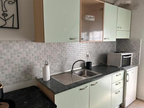 a kitchen with a sink and a microwave at Elxie House in Xanthi