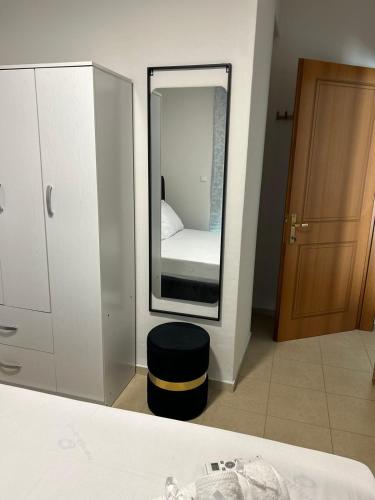 a mirror in a room with a bed and a stool at Elxie House in Xanthi