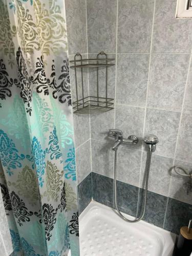 a shower in a bathroom with a shower curtain at Elxie House in Xanthi